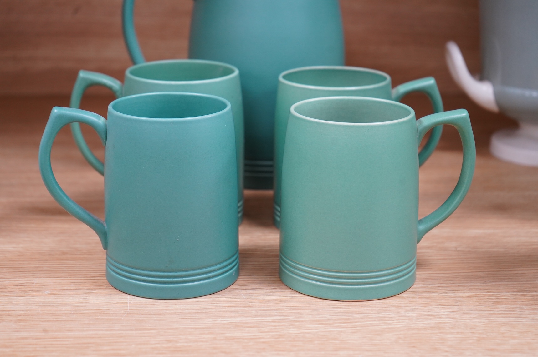 Keith Murray for Wedgwood green glazed lemonade jug and four green mugs, largest 21cm high